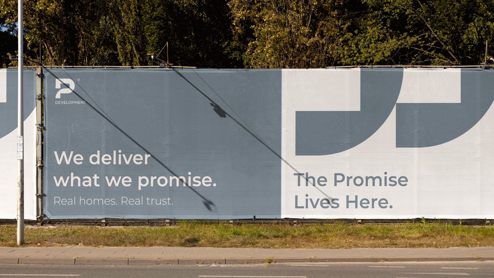 Site hoarding — “The Promise Lives Here.”